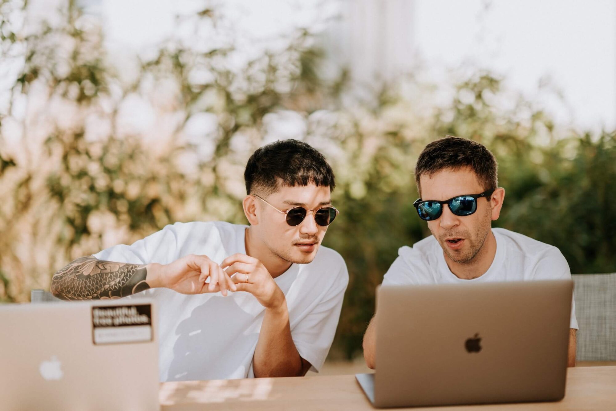 Two young men look at online content on their laptops